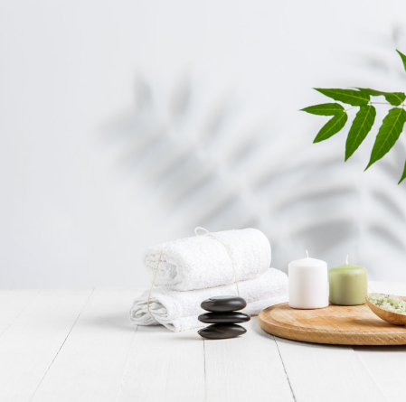 Beautiful spa composition on massage table in wellness center, copyspace. Accessories for relaxing treatments and personal care. Towels, oils, serum, sea salts and scrubs. Decorative candles.