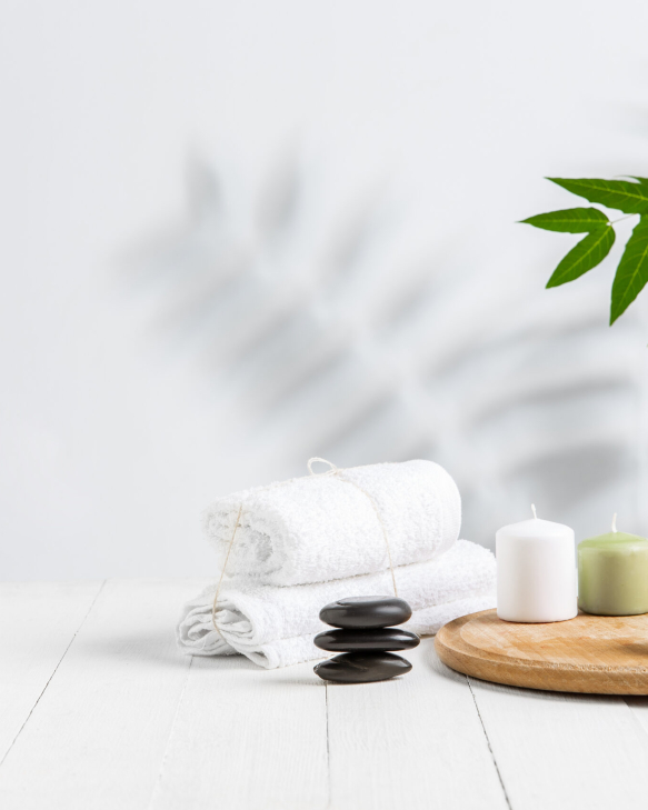 Beautiful spa composition on massage table in wellness center, copyspace. Accessories for relaxing treatments and personal care. Towels, oils, serum, sea salts and scrubs. Decorative candles.